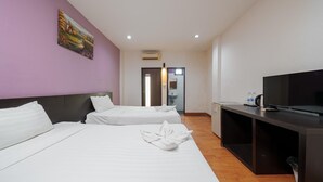 A hotel room with two beds, a TV, a desk, and a painting on the wall.