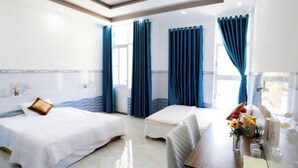 A hotel room with two beds, a small table with a vase of flowers, and a view of the sea through large windows. - Tram Anh Hotel Dong Nai - by BAY LUXURY (Nhon Trach)
