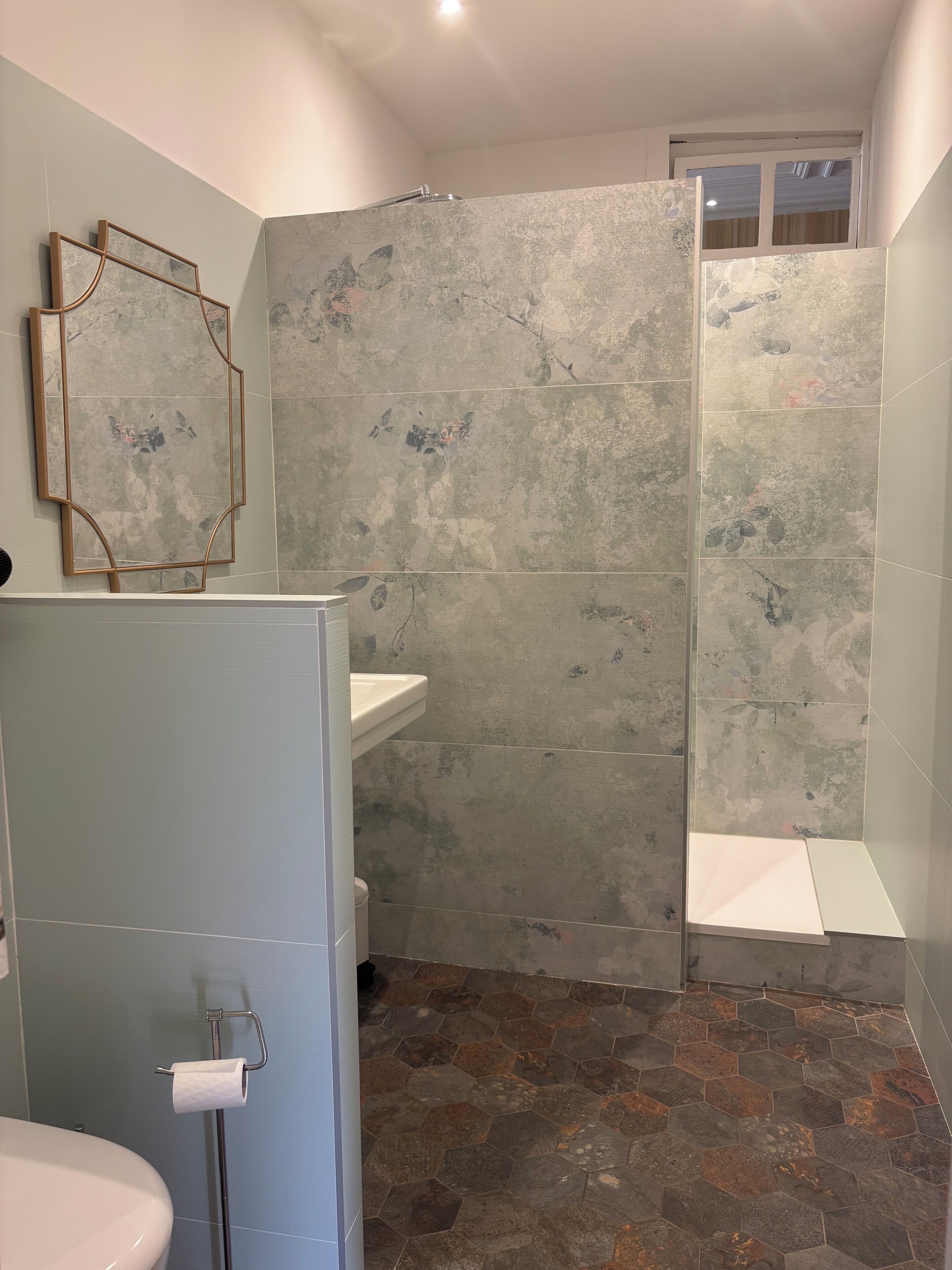 A bathroom with a shower, a sink, and a toilet.