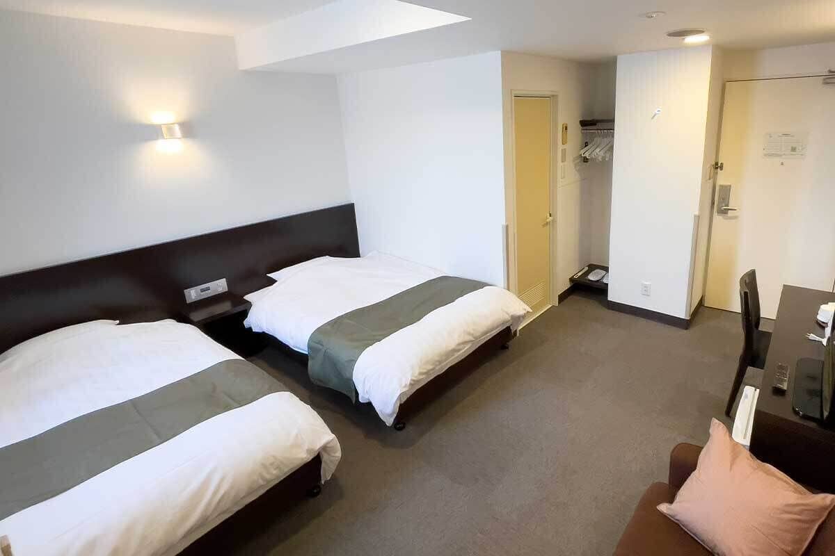 Una habitación de hotel con dos camas, un escritorio y una silla.