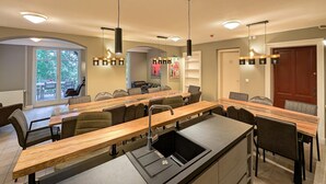 A modern kitchen with a central island, built-in appliances, and pendant lighting.