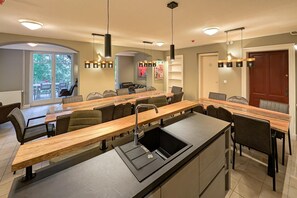 A modern kitchen with a central island, built-in appliances, and pendant lighting.