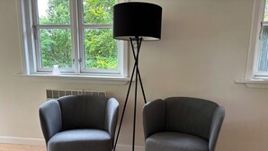 Two grey armchairs, a black floor lamp, and a window with a view of trees. - In beautiful Odsherred, northwest Zealand (Nykøbing Sj)