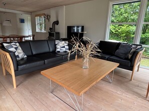 A living room with a black sofa, a wooden coffee table, and a TV. - In beautiful Odsherred, northwest Zealand (Nykøbing Sj)