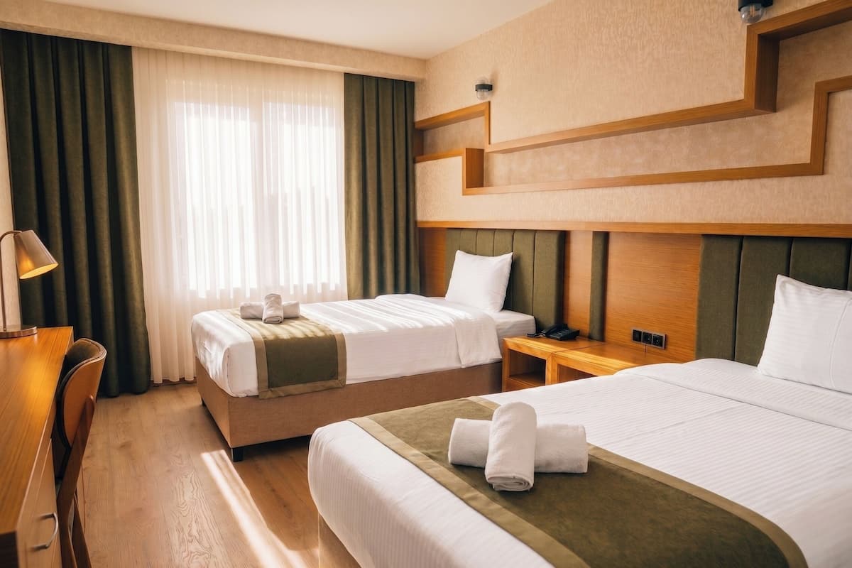 Una habitación de hotel con dos camas, un escritorio y una silla.