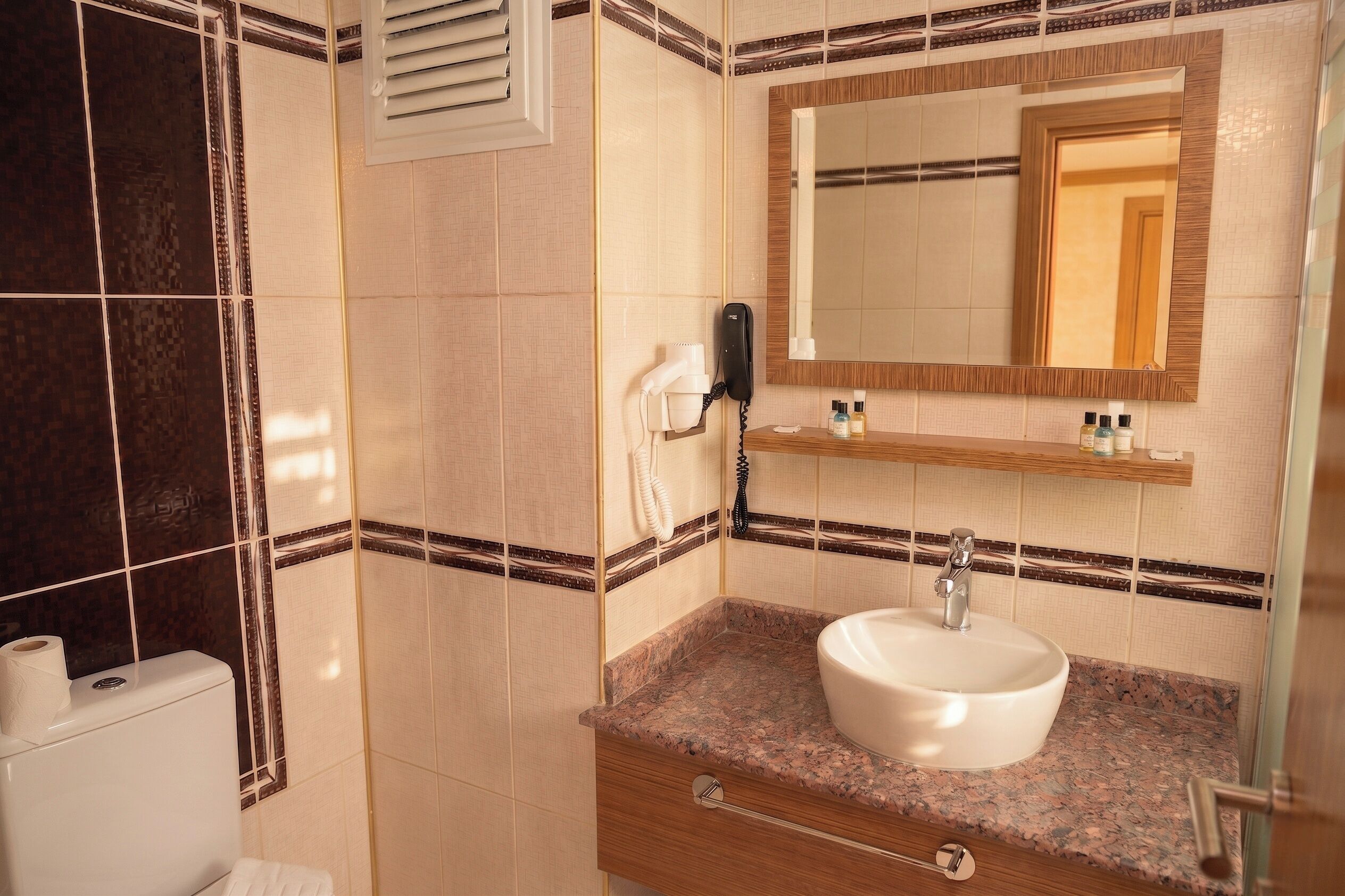 A bathroom with a sink, mirror, towel rack, and toilet.