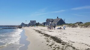 A beach with houses along the shore, a clear sky, and people on the sand. - Gorgeous Home 1 mile to Beach, by Cape Cod Bikepath (Dennis)