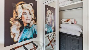 A room with a large poster of a woman, a wooden chair, and a bed with white bedding and a floral pillow. - Pink Dreams - Walk to Live Music, Bars, Restaurants - Free Parking (Nashville)