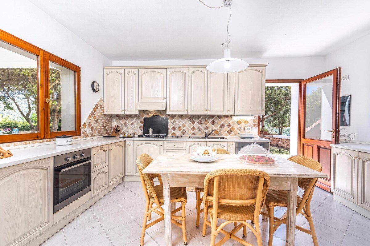 A kitchen with a dining table, chairs, and a stove.