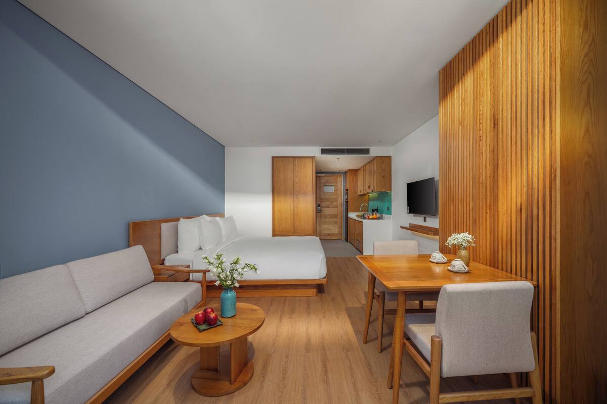 Une chambre d’hôtel moderne équipée d’un canapé, d’un lit, d’une table à manger et d’un téléviseur.