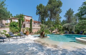 A pool area with lounge chairs, a clear pool, and a building with balconies. - Lovely home in Saint-Maximin-la-Saint (Saint-Maximin-la-Saint)