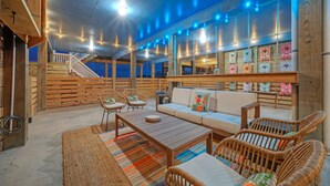 A cozy, well-lit interior with a wooden staircase, comfortable seating, and a display of textiles. - Salty Texan by AvantStay | Central Location, Views (Port Aransas)