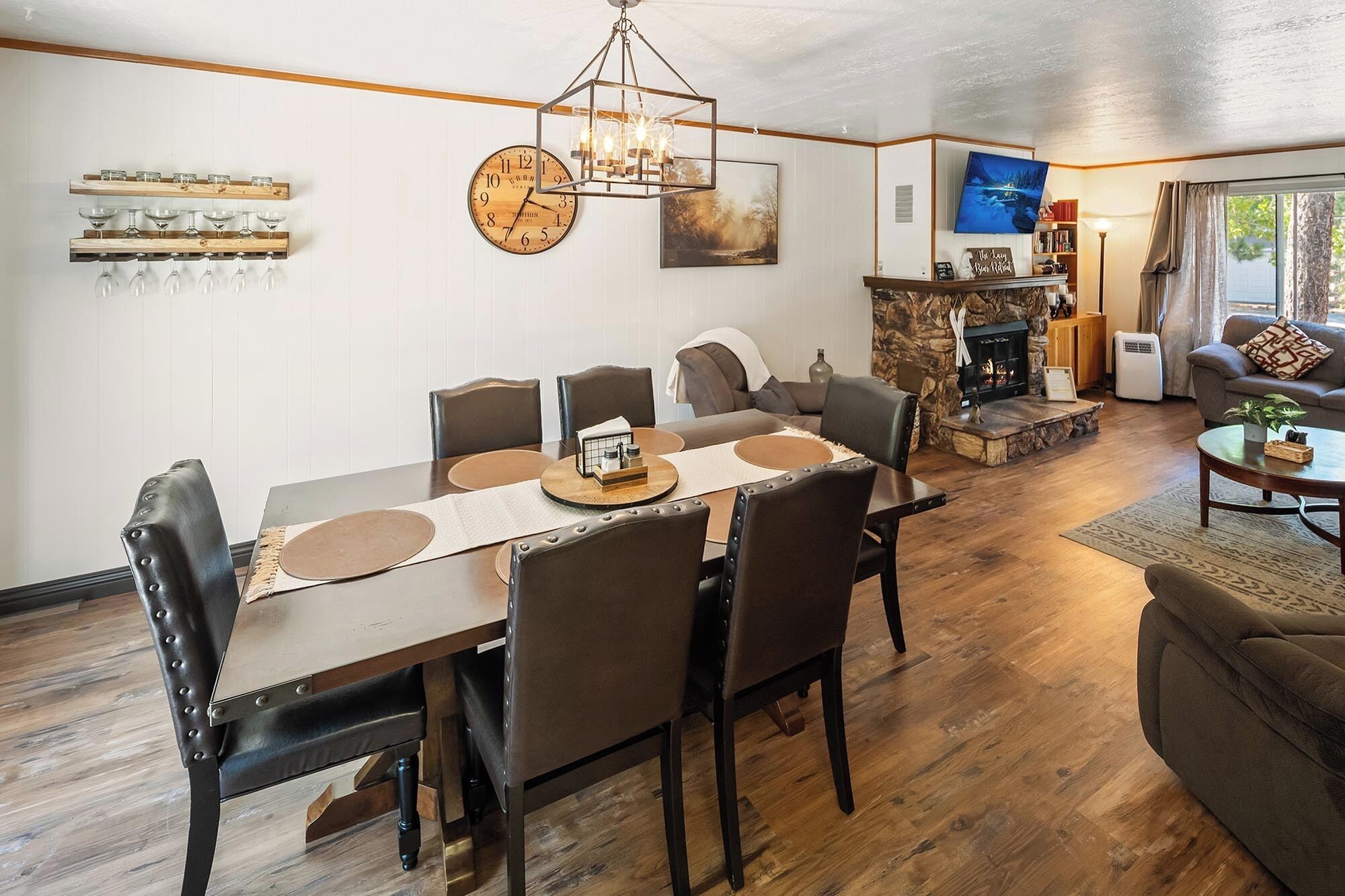A dining area with a wooden table, chairs, and a clock on the wall.