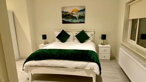 A bedroom with a bed, two nightstands, a painting, and a window. - Modern Family Home (Castleisland)