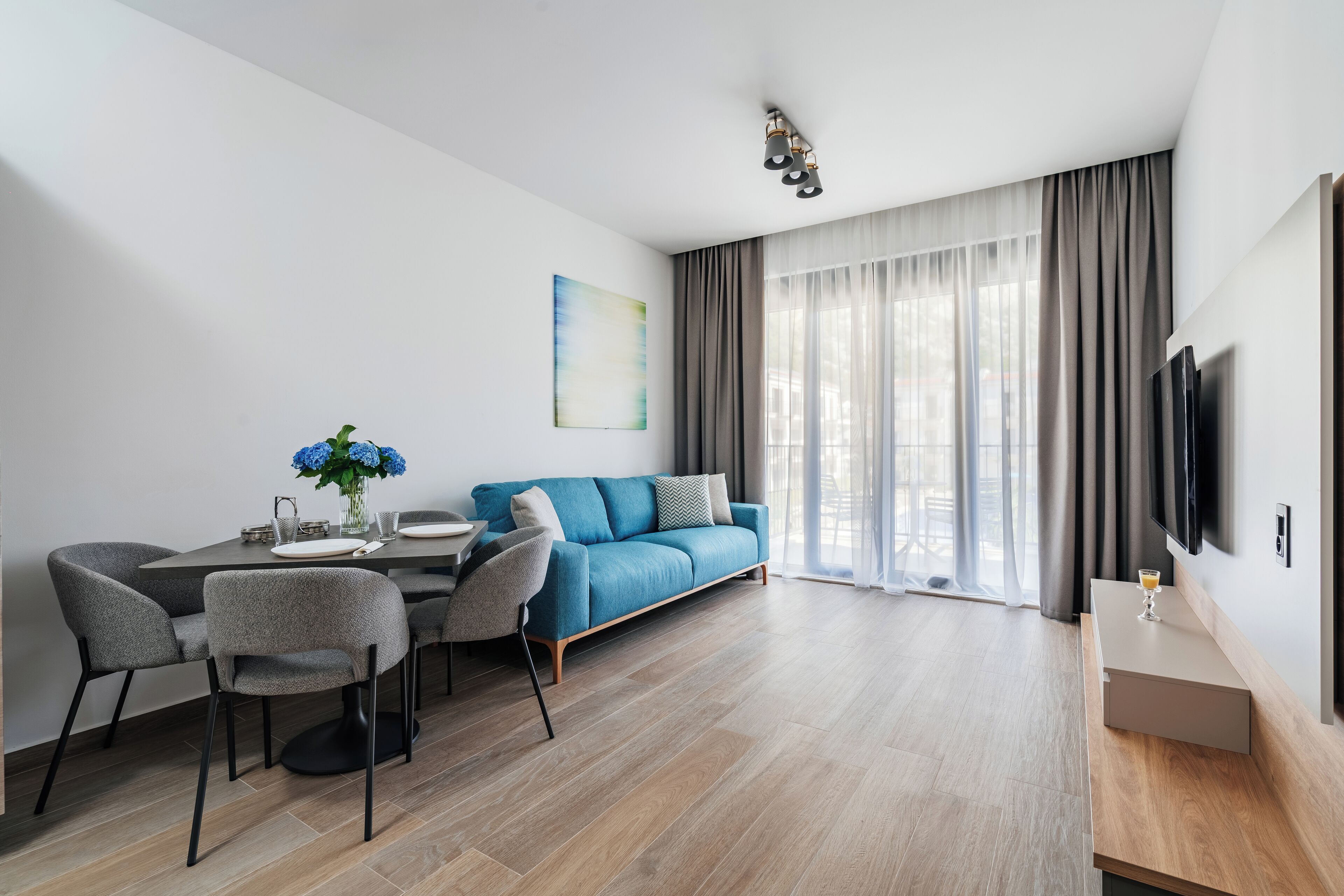 A modern living room with a sofa, dining table, and chairs.