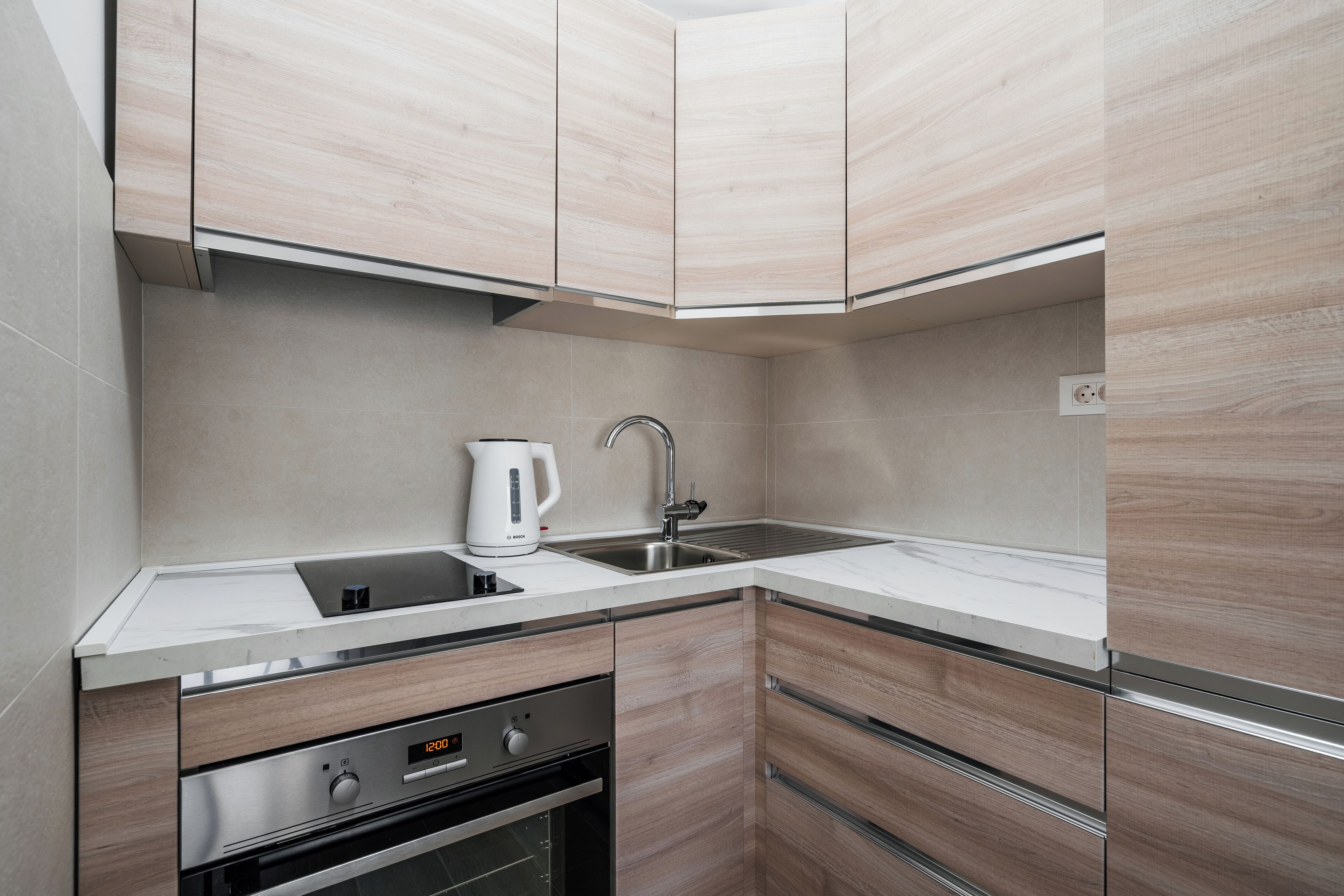 A modern kitchen with wooden cabinets, a stainless steel sink, and a Bosch coffee maker.