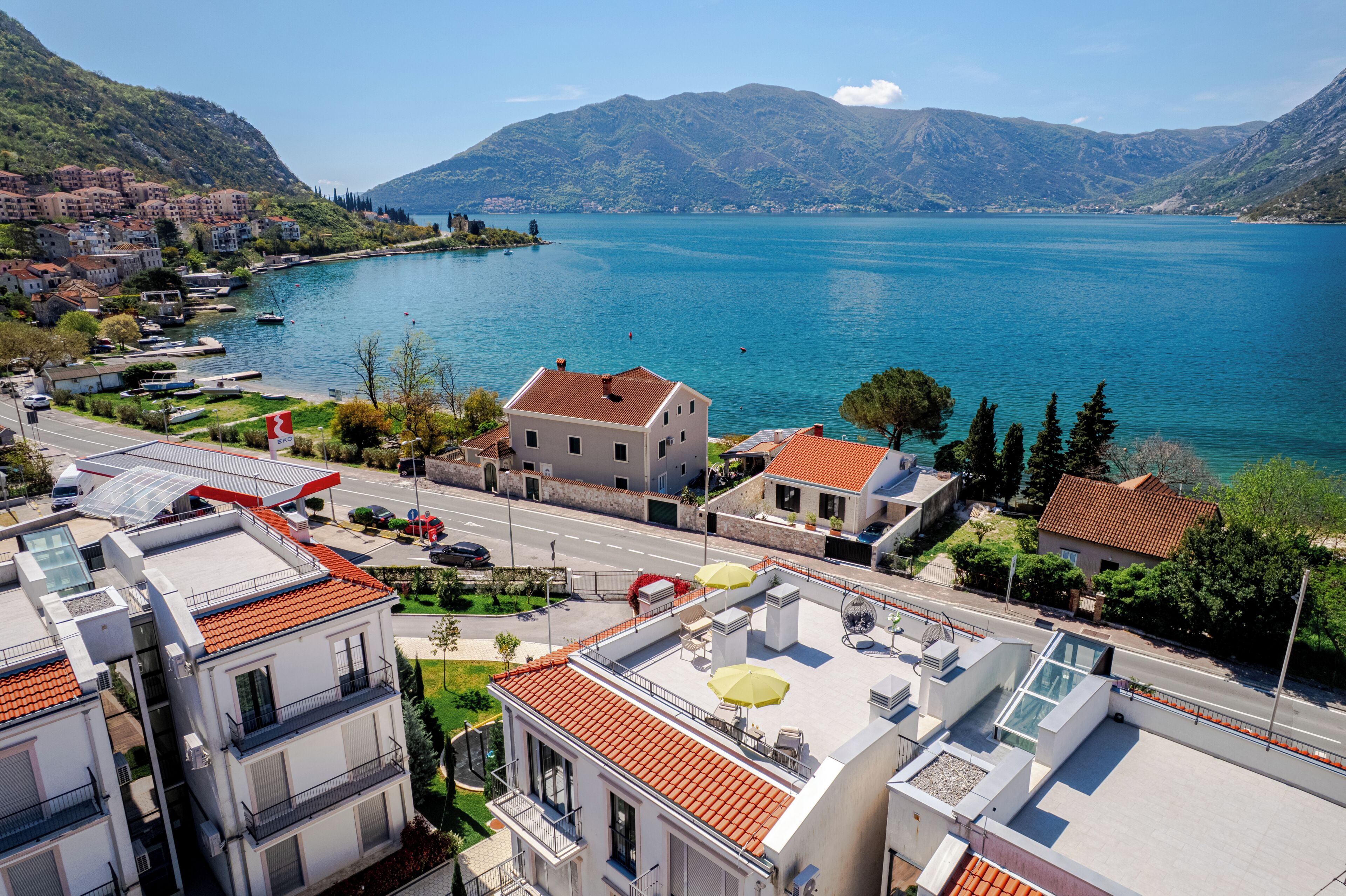 A coastal town with buildings, a road, and a lake.