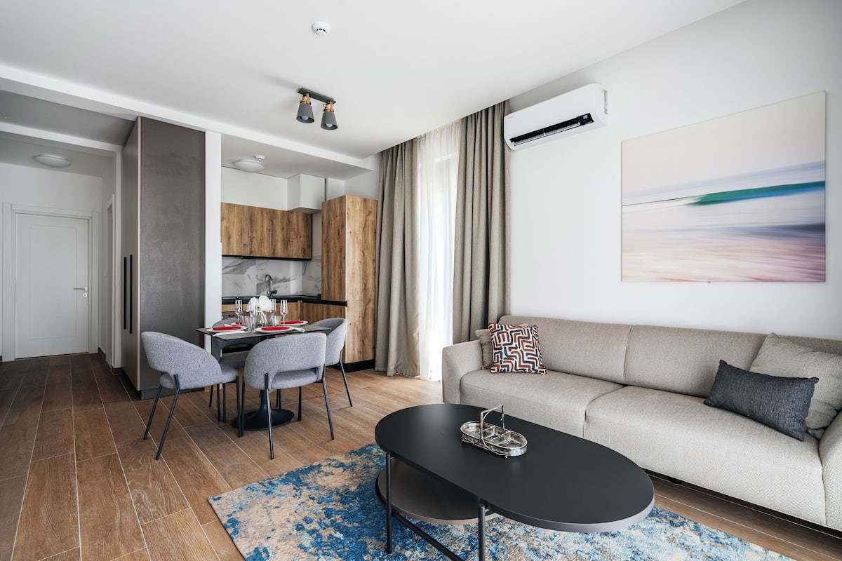 Un salon moderne avec un canapé, une table basse et un coin repas.