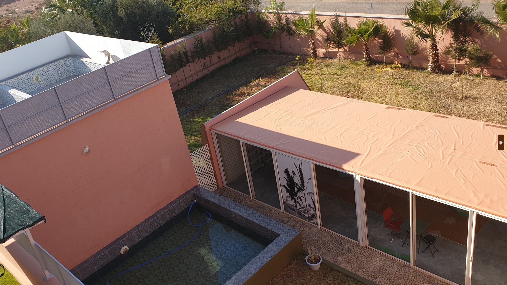A modern building with a flat roof, a small pool area, and a covered patio.