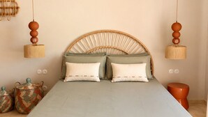 A bed with a wooden frame, two hanging lamps, and a woven headboard. - Sunset Suite Sardinia 0.4 (Porto Rotondo)