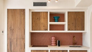 A kitchen with wooden cabinets, a countertop, and a backsplash. - Sunset Suite Sardinia 0.4 (Porto Rotondo)