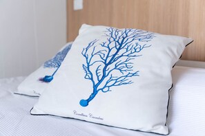 A pillow with a blue tree design on a bed. - Sunset Suite Sardinia 0.9 (Porto Rotondo)