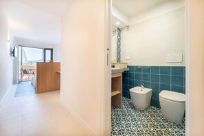 A modern bathroom with a bidet, a toilet, and a sink.