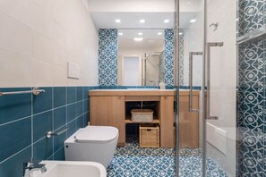 Une salle de bain avec des toilettes, un lavabo et une douche.