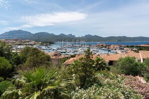 Un port de plaisance avec des bateaux, entouré de bâtiments résidentiels et de montagnes.