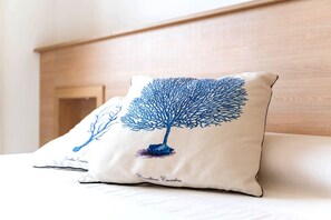 A pillow with a tree design on a bed.