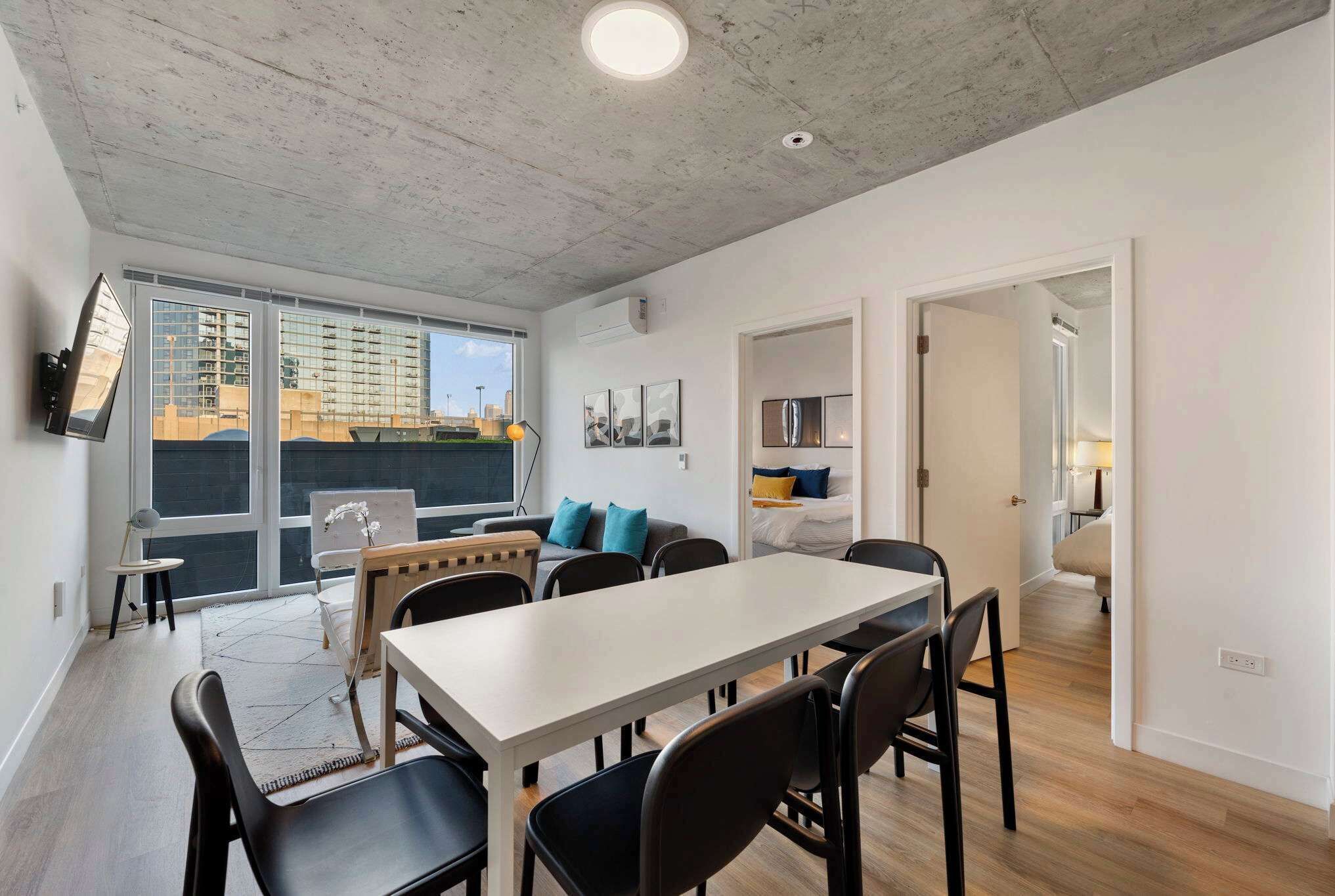 Un appartamento moderno con zona pranzo, angolo soggiorno e vista sulla città.