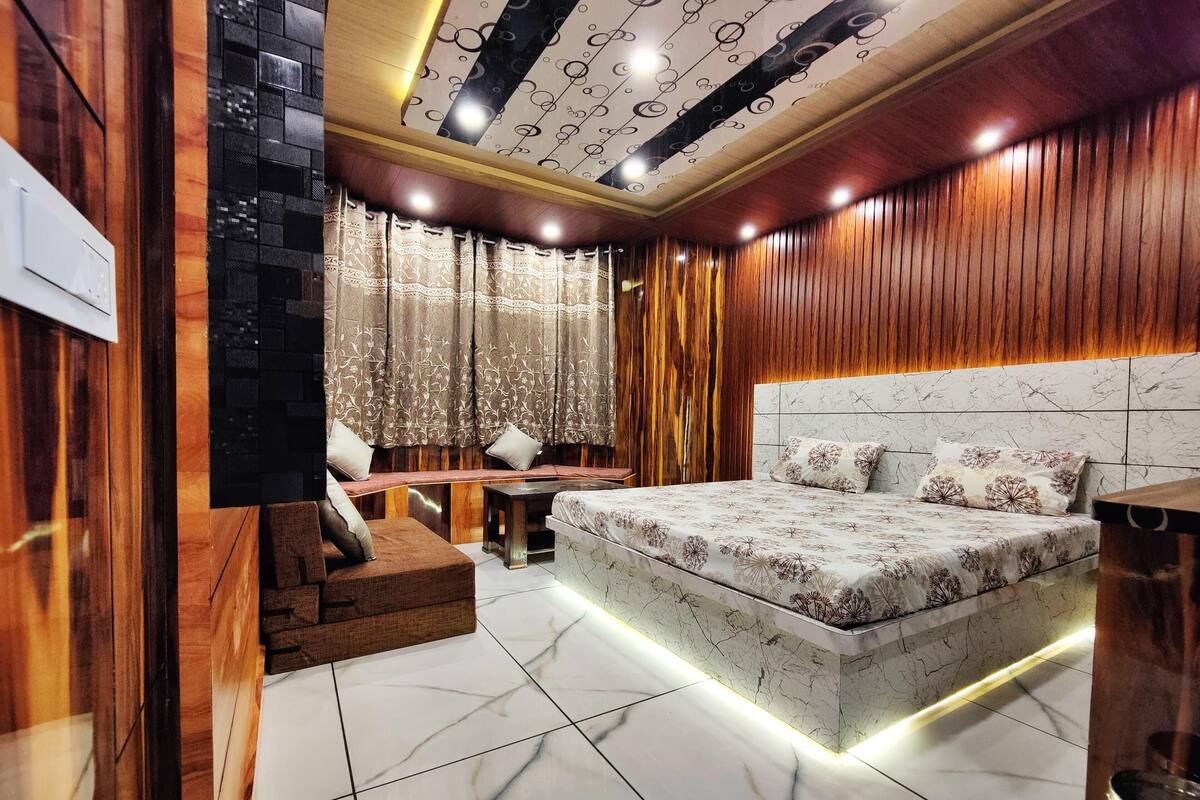 A bedroom with a large bed, a bench, and a small table.