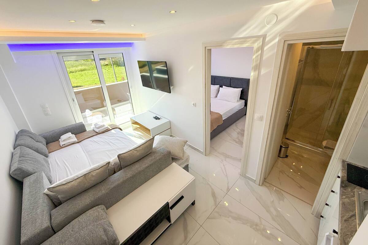 A modern bedroom with a bed, bedside tables, and a TV.