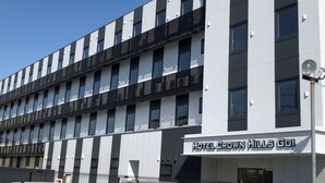 Un moderno edificio de hotel con un letrero que dice "Hotel Crown Hills GOI".