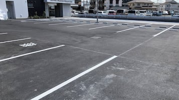 A parking lot with marked spaces, a building labeled "Hotel Crown Hills Go" in the background, and a clear sky.