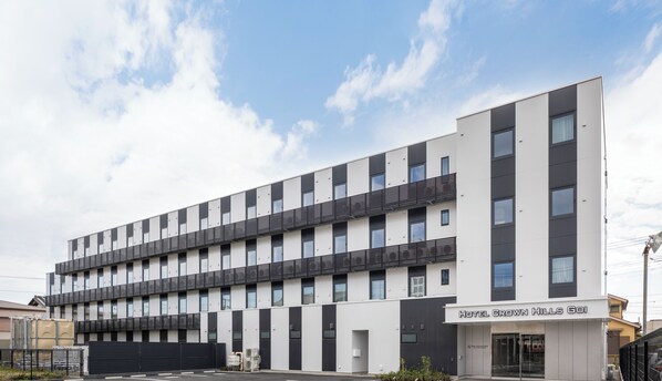 A modern hotel building with a flat facade, multiple balconies, and a clear sky. - Hotel Crown Hills Goi (Ichihara)