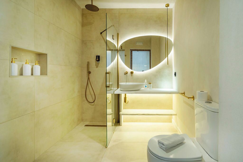 Une salle de bain moderne avec une douche à parois de verre, un meuble-lavabo avec un miroir et des toilettes.