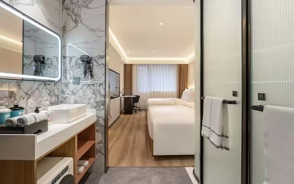 A modern hotel room with a marble bathroom, a bed with a white headboard, and a large mirror. - Beijing Anzhenxiyue Hotel (Beijing)