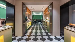 Una cocina moderna con piso de tablones, electrodomésticos integrados y una isla central.