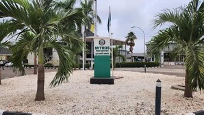 A sign for 'MITROS Residences & Gateway Annex' with palm trees and a building in the background. - Mitros Boutique Hotel  (Abeokuta)