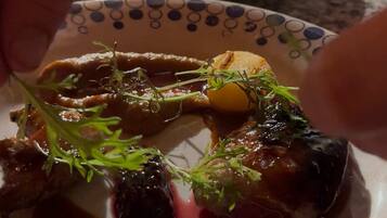Une vue rapprochée d’un plat contenant de la viande et des légumes, présenté sur une assiette à motifs.