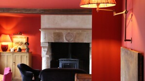A cozy room with a fireplace, a lamp, and a chair. - Auberge Bout de Bois (Saint-Jouin-Bruneval)