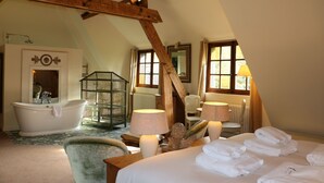 A room with a large bed, a bathtub, a chair, and a lamp. - Auberge Bout de Bois (Saint-Jouin-Bruneval)
