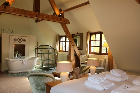 A room with a large bed, a bathtub, a chair, and a lamp. - Auberge Bout de Bois (Saint-Jouin-Bruneval)