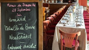 A restaurant with a chalkboard menu, wooden chairs, and a long dining table. - Auberge Bout de Bois (Saint-Jouin-Bruneval)