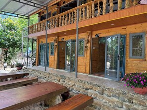 Ein Holzhaus mit Balkon, einem Steinweg und Holzbanken.