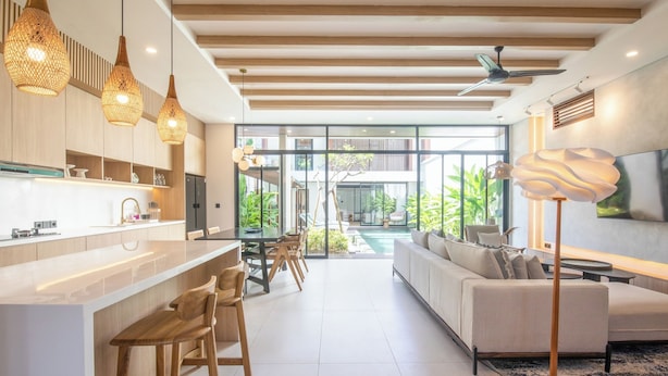 A modern kitchen with a central island, wooden bar stools, and pendant lighting. - Chic 3BR Hideaway Canggu AC 5min to Beach (Tibubeneng)