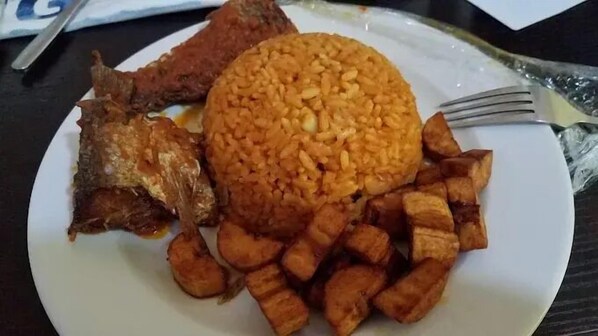 A plate with fried fish, rice, and fried plantains.