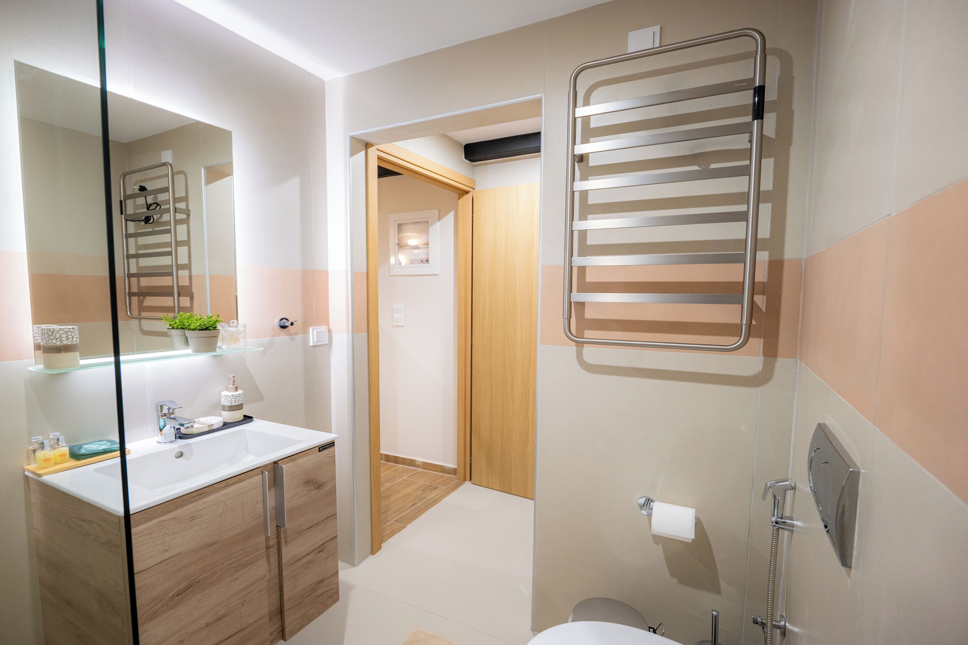 Een moderne badkamer met een douchecabine van glas, een ingebouwd wastafelmeubel en een handdoekrek.