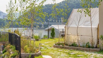 A garden with stepping stones, a metal fence, and a building with a white exterior.